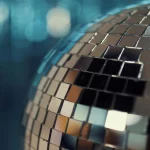 Hier sieht man einen Teil einer großen Discokugel. Der Hintergrund wird von der Kugel reflektiert und ist verschwommen. Corporate Events Firmenfeier