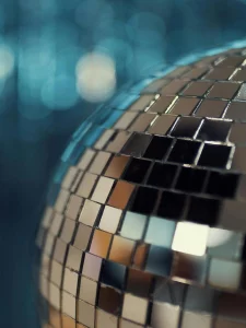 Hier sieht man einen Teil einer großen Discokugel. Der Hintergrund wird von der Kugel reflektiert und ist verschwommen. Corporate Events Firmenfeier